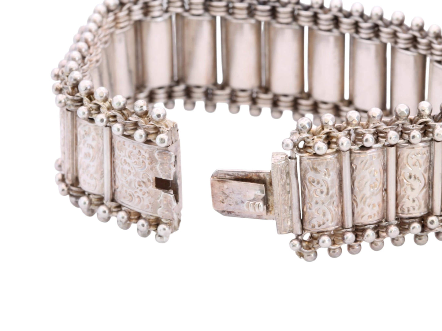 Open antique silver bracelet showing articulated panels and concealed clasp