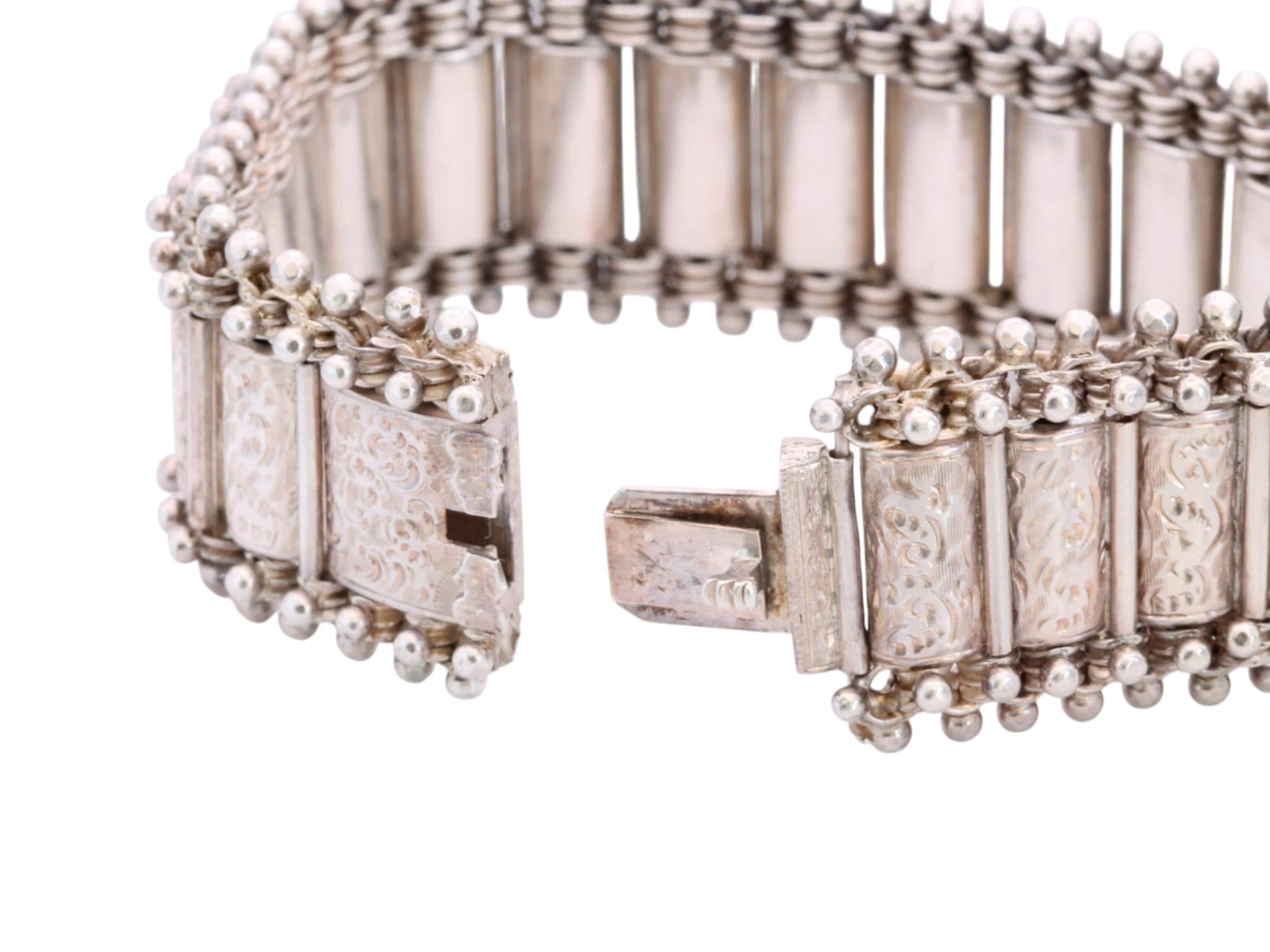 Open antique silver bracelet showing articulated panels and concealed clasp