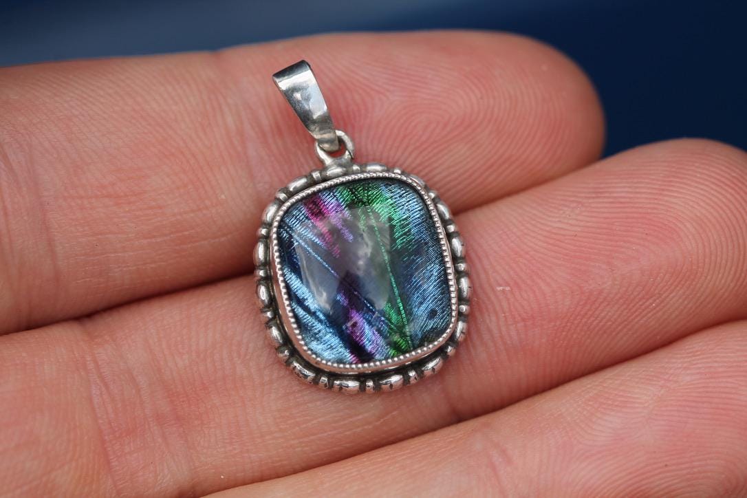 Art Deco sterling silver butterfly wing pendant showing iridescent blue, green and purple wing