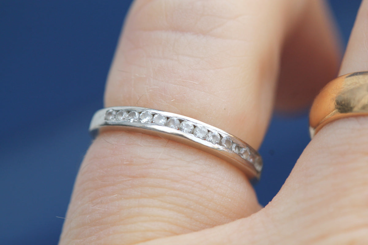 Close-up of fourteen small diamonds set across white gold band