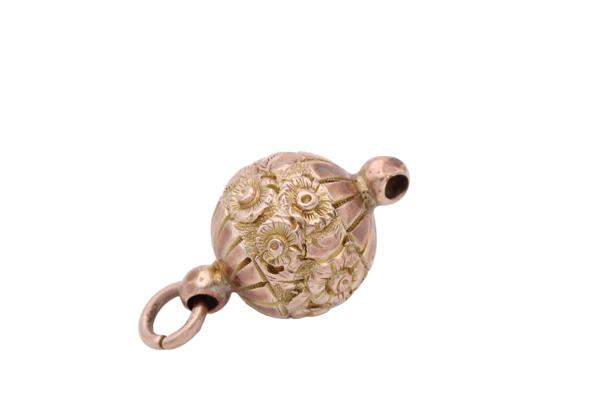 Side view of Victorian gold ball pendant showing floral engraving
