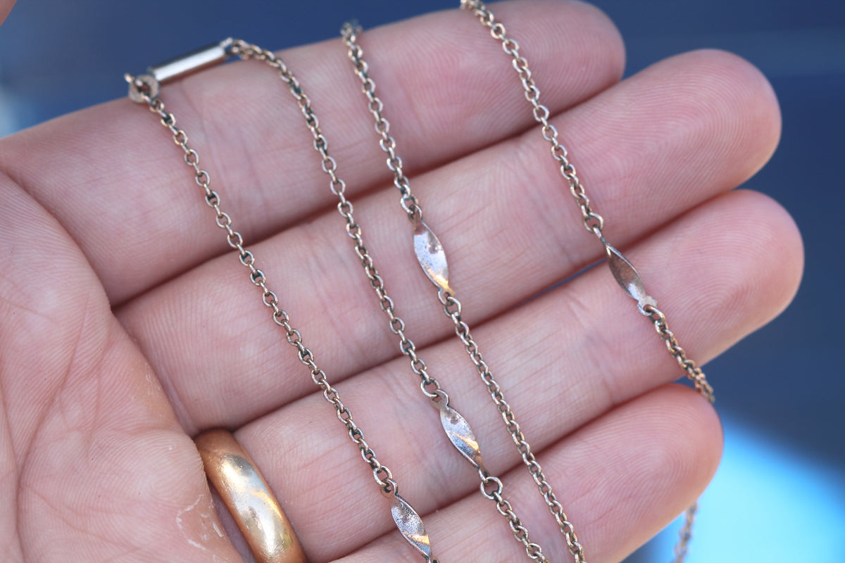 Close-up of fine antique chain showing elongated swirl station links