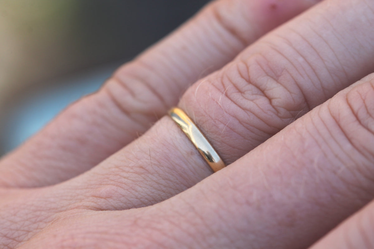 Slim antique 18ct gold wedding ring worn on the finger