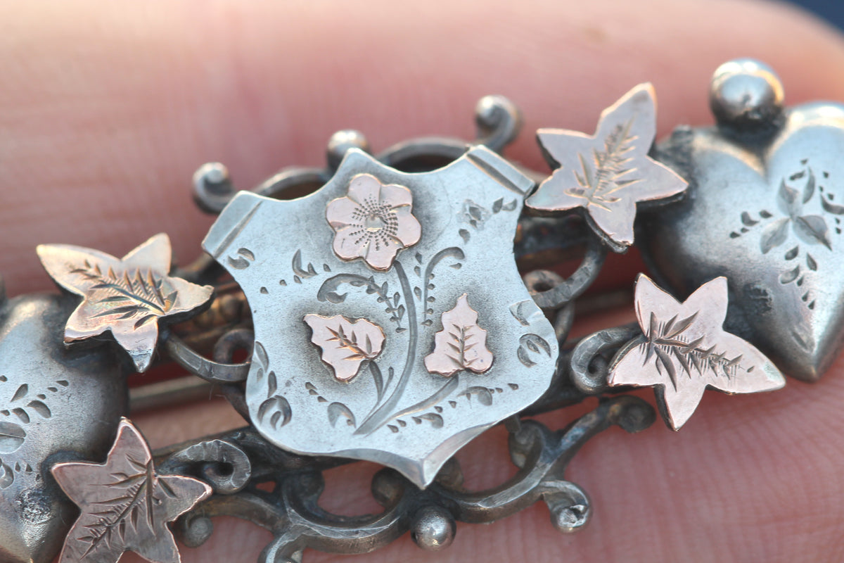Antique Edwardian two-colour silver and gold brooch shown in the hand