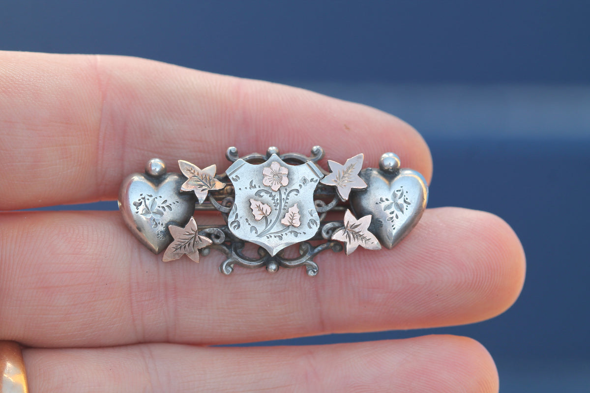 Close-up of central shield with engraved flowers and 9ct gold ivy highlights