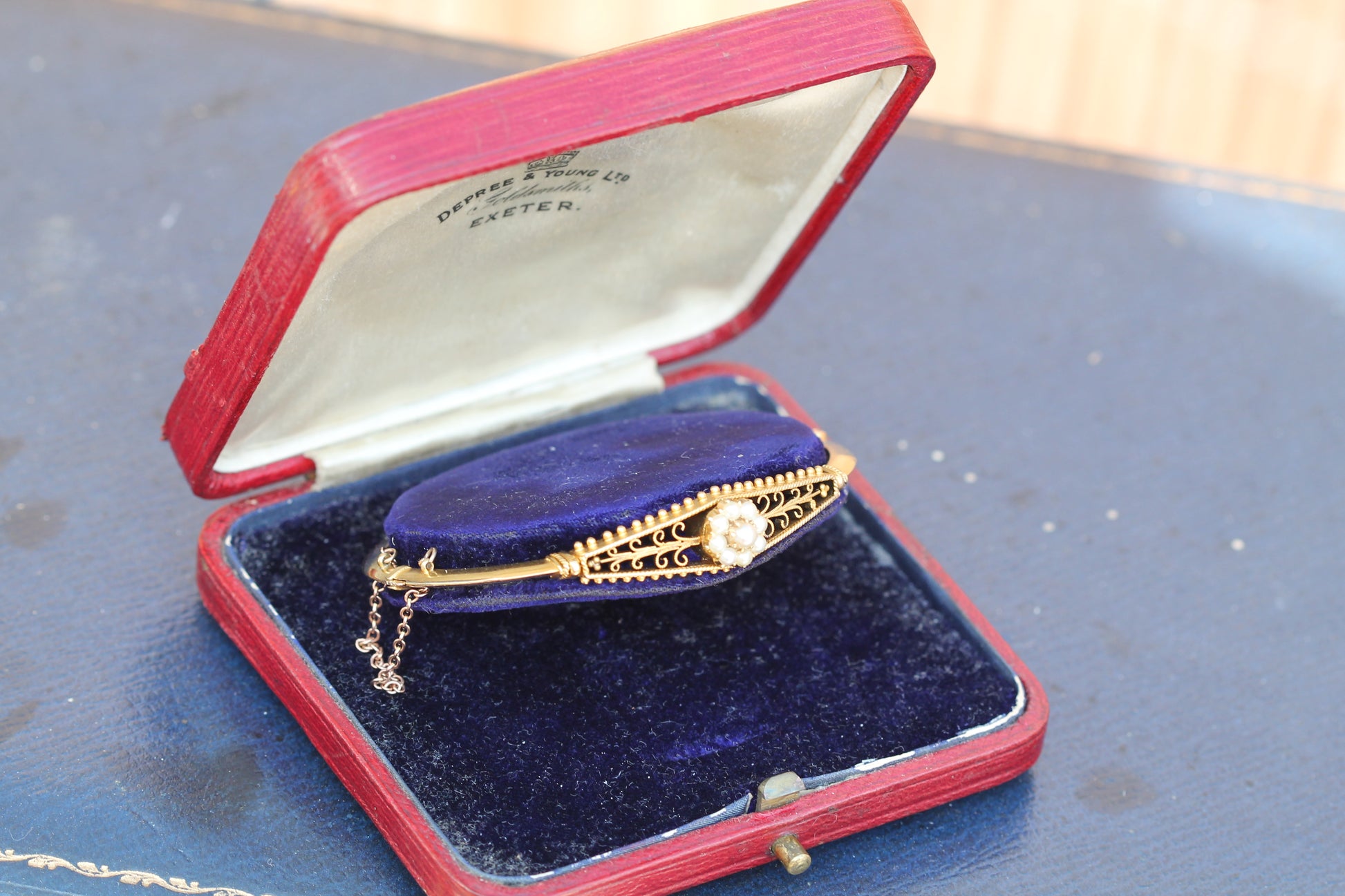 Reverse of antique gold bangle showing detailed construction behind pearl cluster