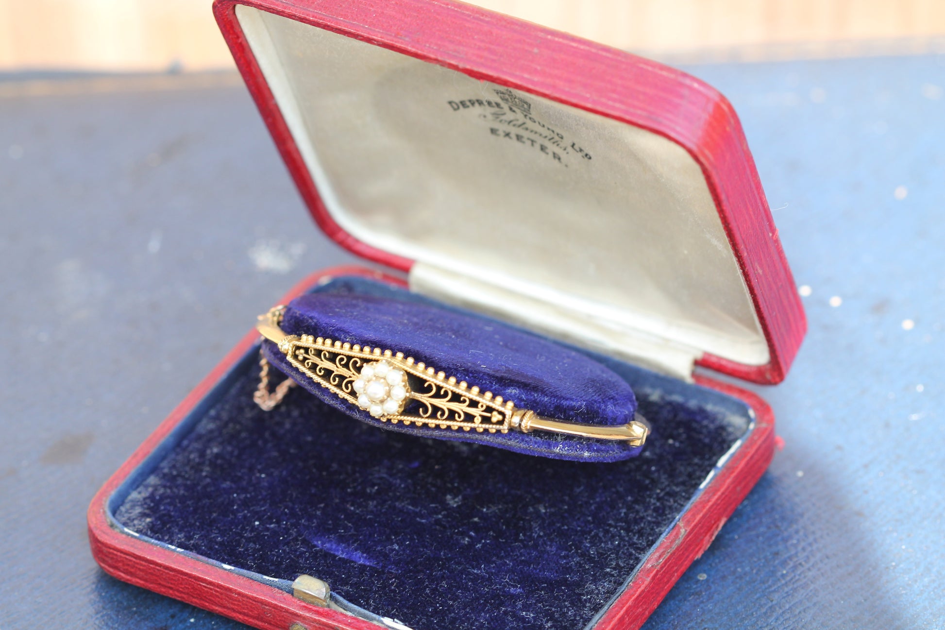 Edwardian 15ct gold pearl bangle displayed in its original fitted jewellery box