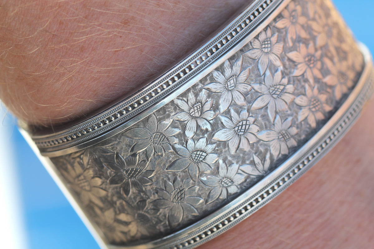 Victorian silver bangle worn on the wrist showing floral engraving