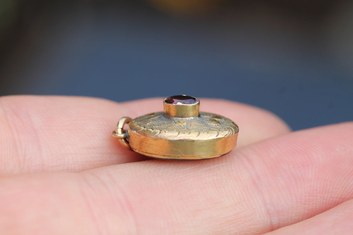 Reverse of Victorian garnet locket showing glazed keepsake compartment