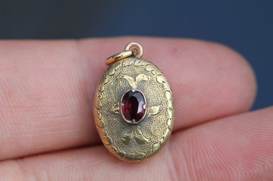Antique Victorian 15ct gold garnet keepsake locket with engraved floral decoration
