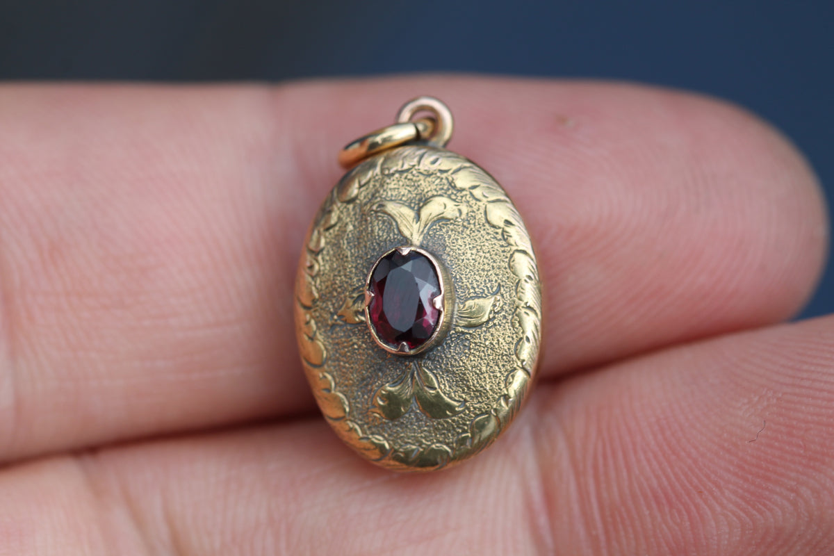 Close-up of Victorian gold locket showing central oval garnet