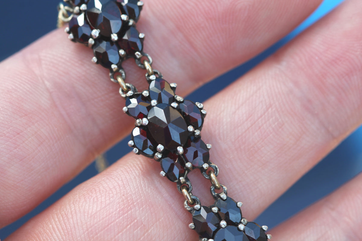 Antique bracelet showing deep red faceted garnet flower clusters