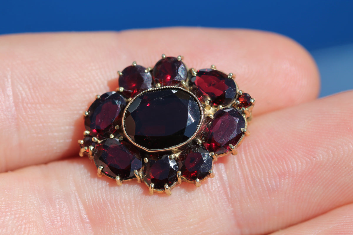 Reverse of vintage garnet brooch showing open-backed settings and pin