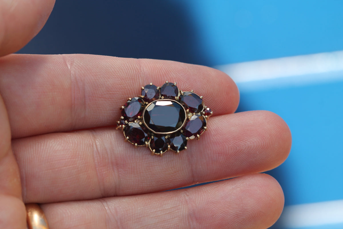 Front view of mid-century silver gilt garnet floral cluster brooch