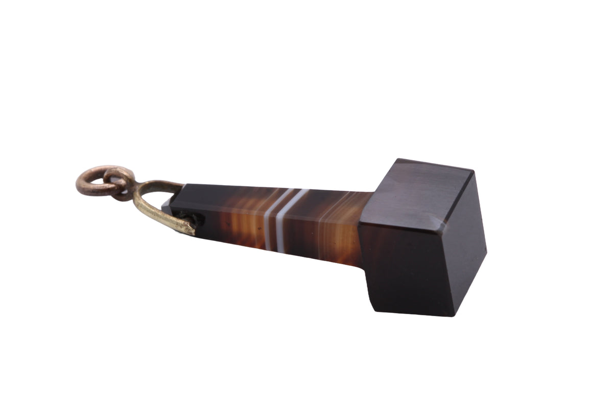 Banded agate pendant held in hand showing natural striped layers