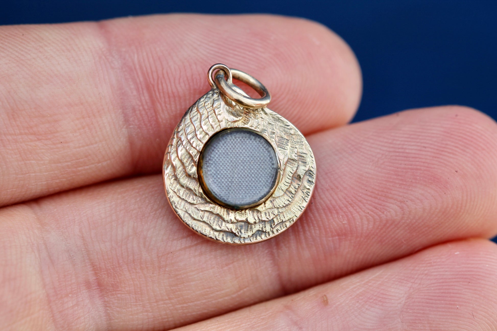 Side view of Victorian gold oyster shell pendant showing raised texture