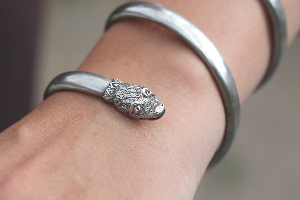 Close-up of antique silver snake bracelet showing detailed serpent head