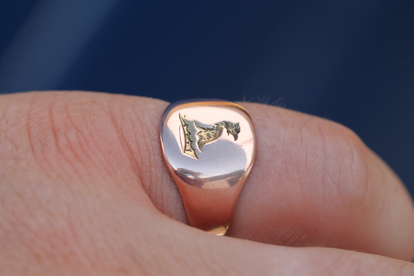 Antique rose gold griffin signet ring worn on the hand