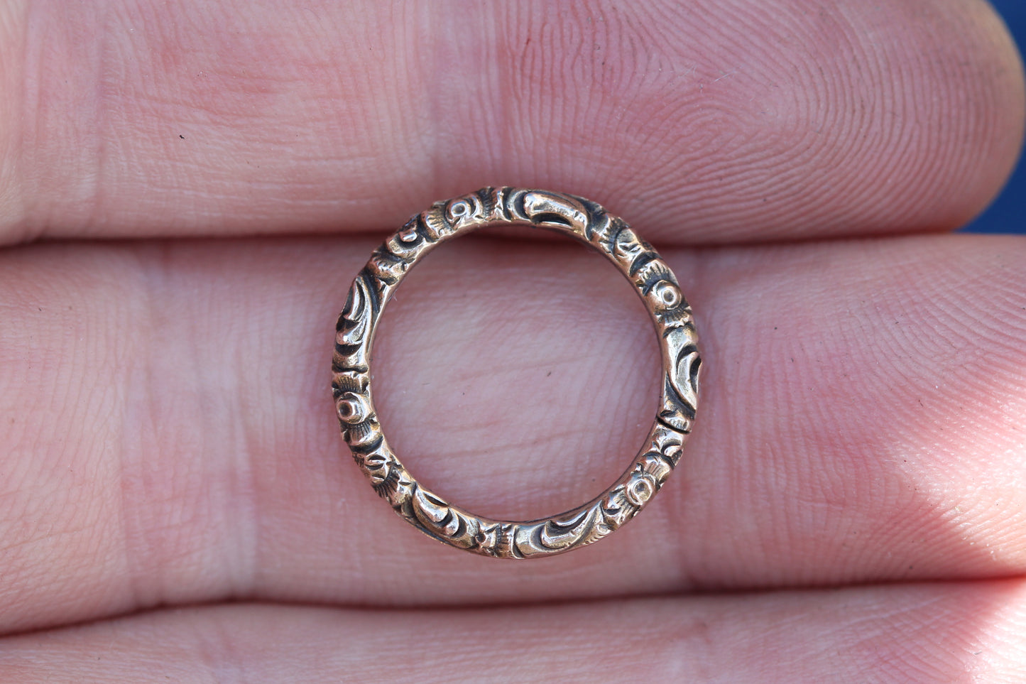 Close-up of antique 9ct gold split ring showing engraved detail and split construction