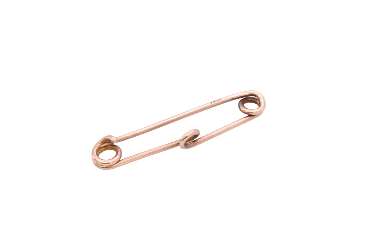 Side view of 9ct rose gold safety pin showing 9CT stamp