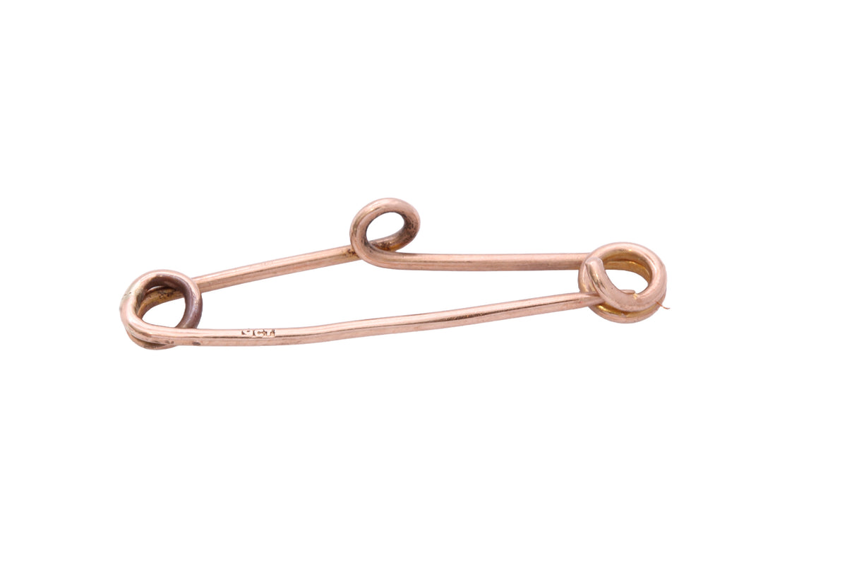 Antique gold safety pin shown in the hand