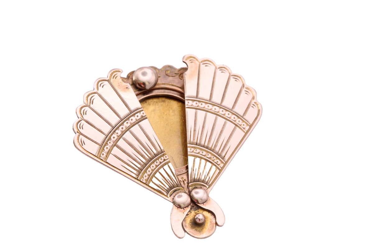 Open antique gold fan brooch revealing hidden photograph compartment