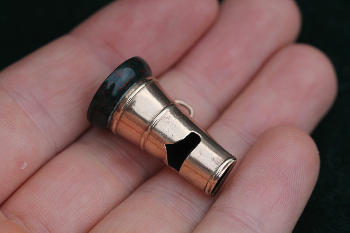 Victorian 9ct gold whistle pendant shown in the hand