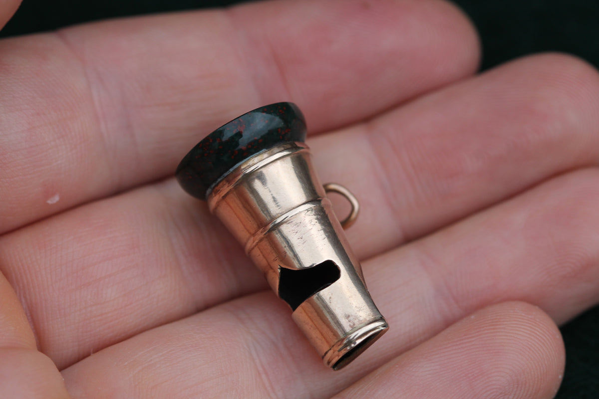 Close-up of antique whistle showing polished green and red bloodstone base
