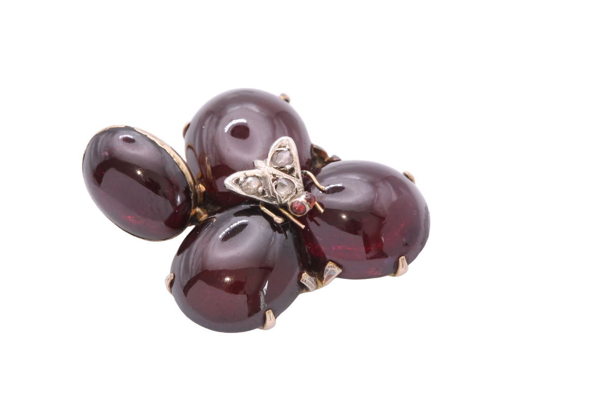 Close-up of Victorian insect pendant showing diamond-set silver fly and garnet eyes