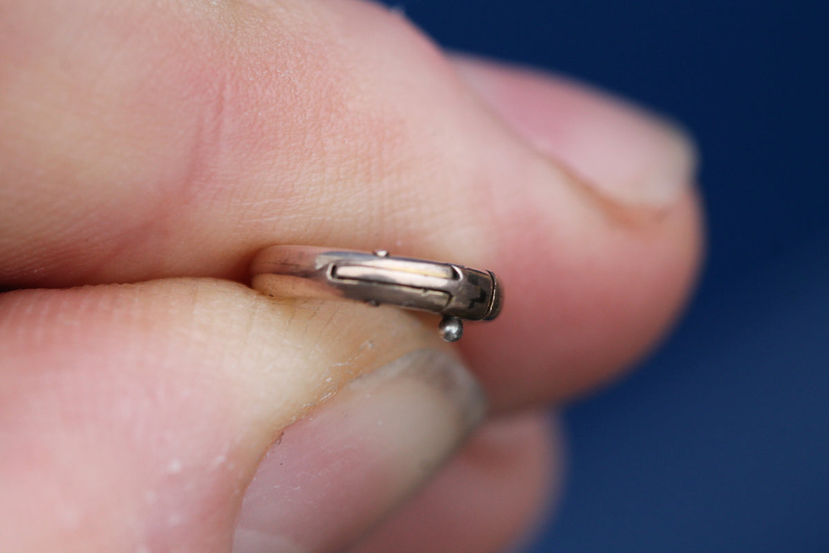 Antique gold spring ring clasp shown open to reveal mechanism