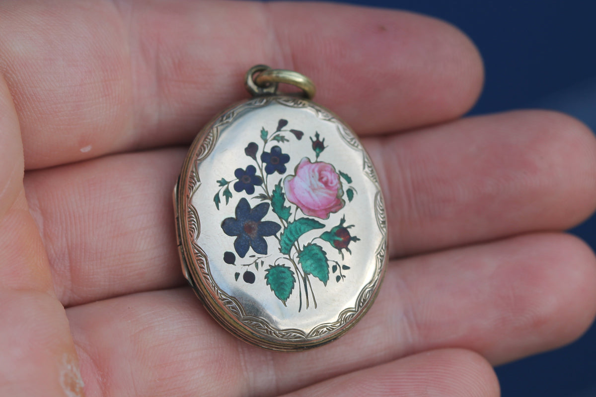 Close-up of Victorian enamel locket with pink rose and blue flowers