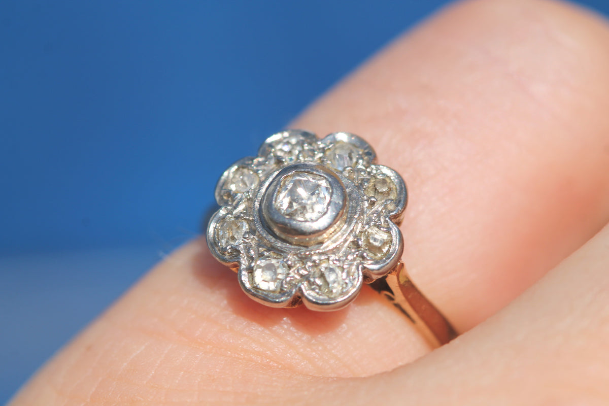 Side view of raised platinum diamond cluster on 18ct gold ring