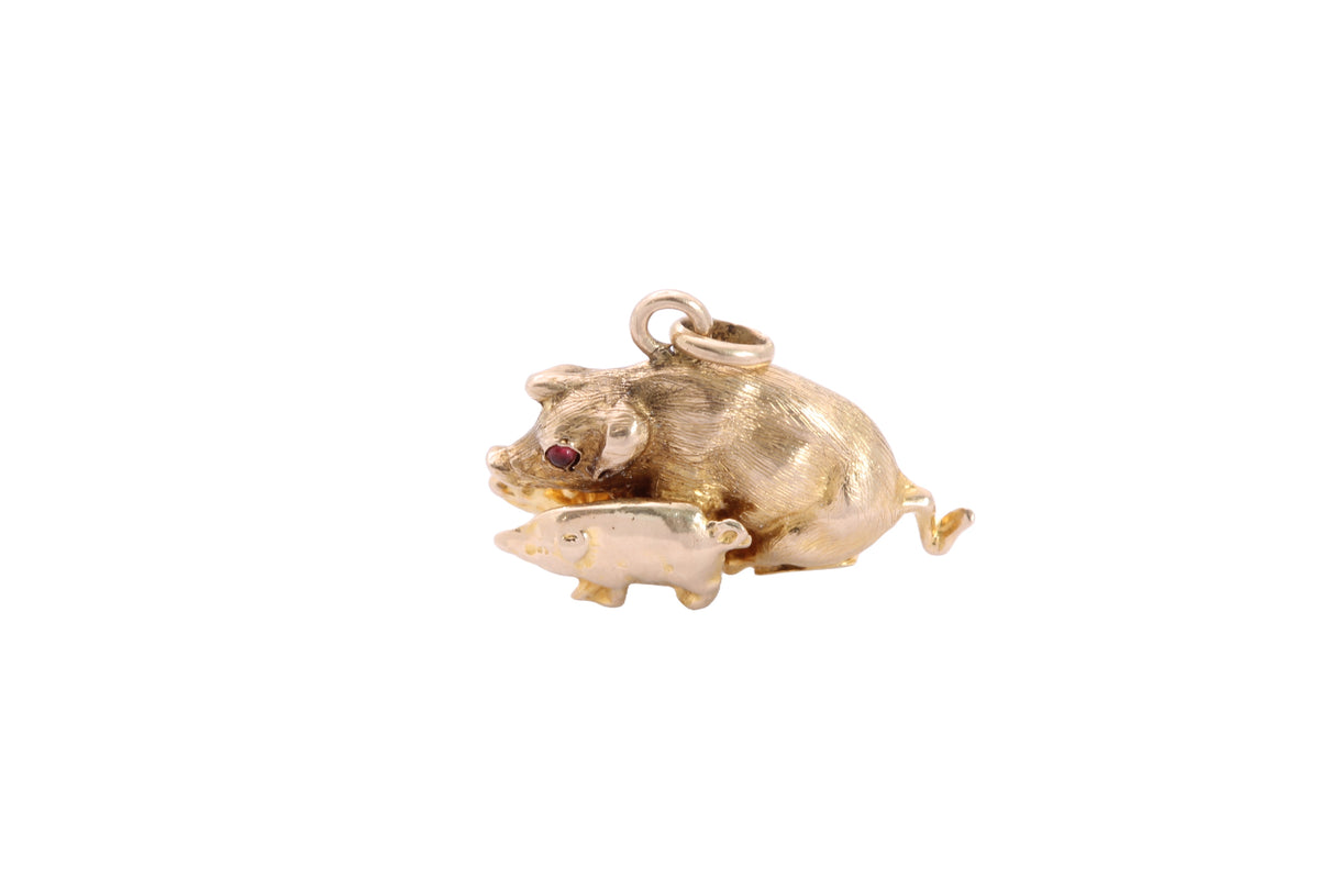 Side view of antique gold pig charm showing sculptural modelling