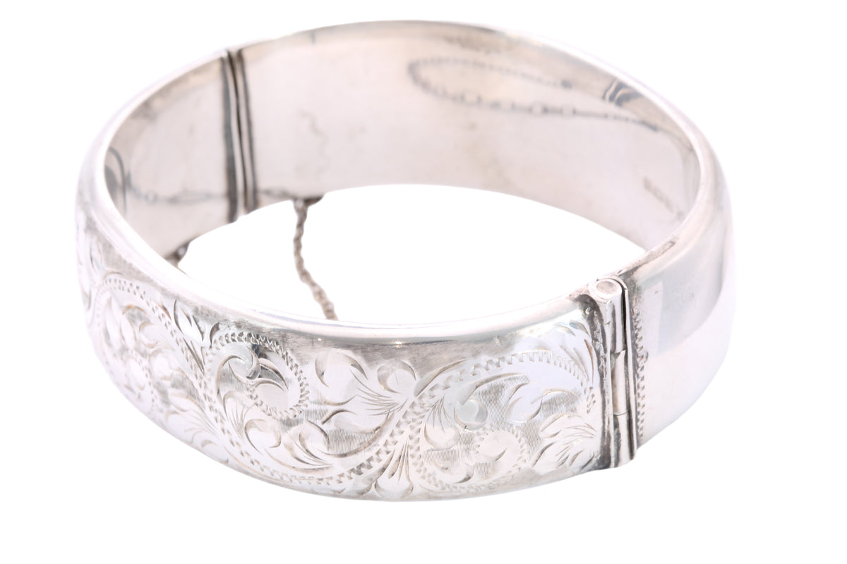 Reverse of vintage silver bangle showing plain back and safety chain