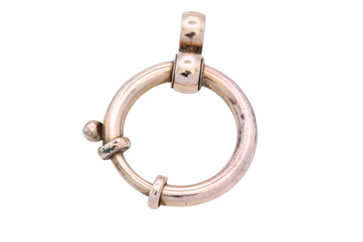 Antique rolled gold circular clasp shown in the hand
