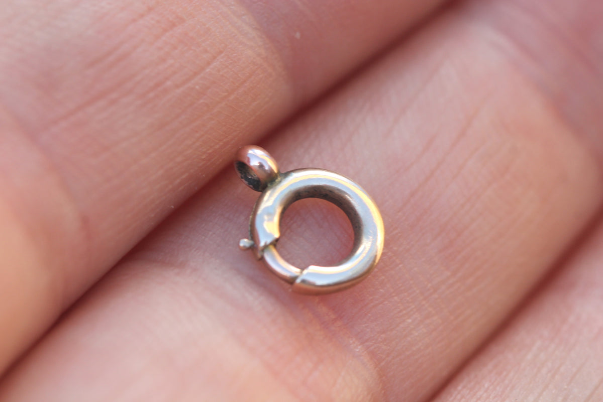 Antique rose gold spring ring clasp showing functional side lever