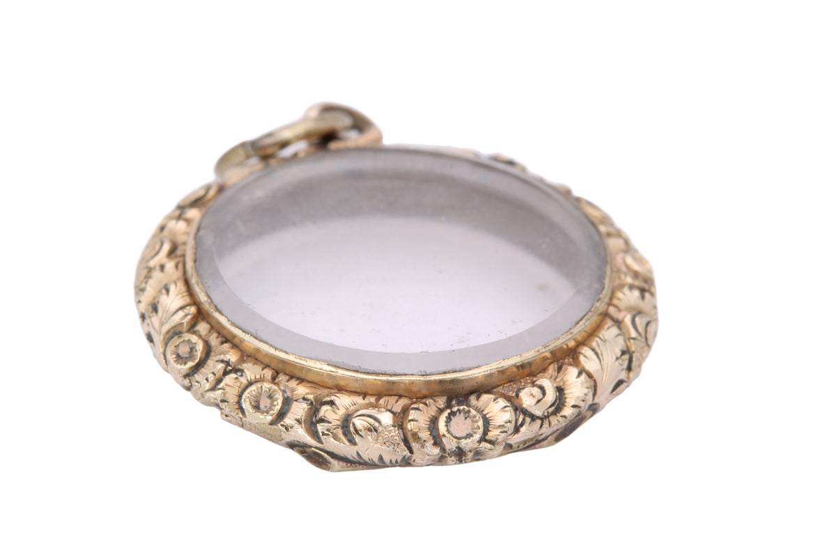Open antique shaker locket showing hinged glass compartment
