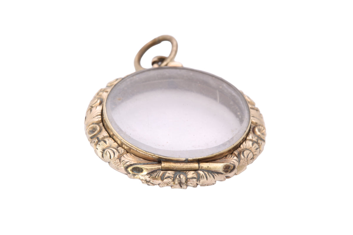 Victorian glass locket showing floral chased gold cased border