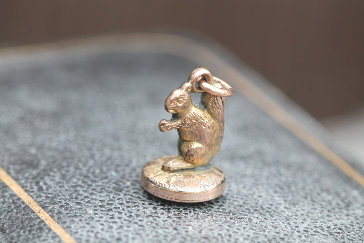 Side view of Victorian squirrel seal charm showing curled tail