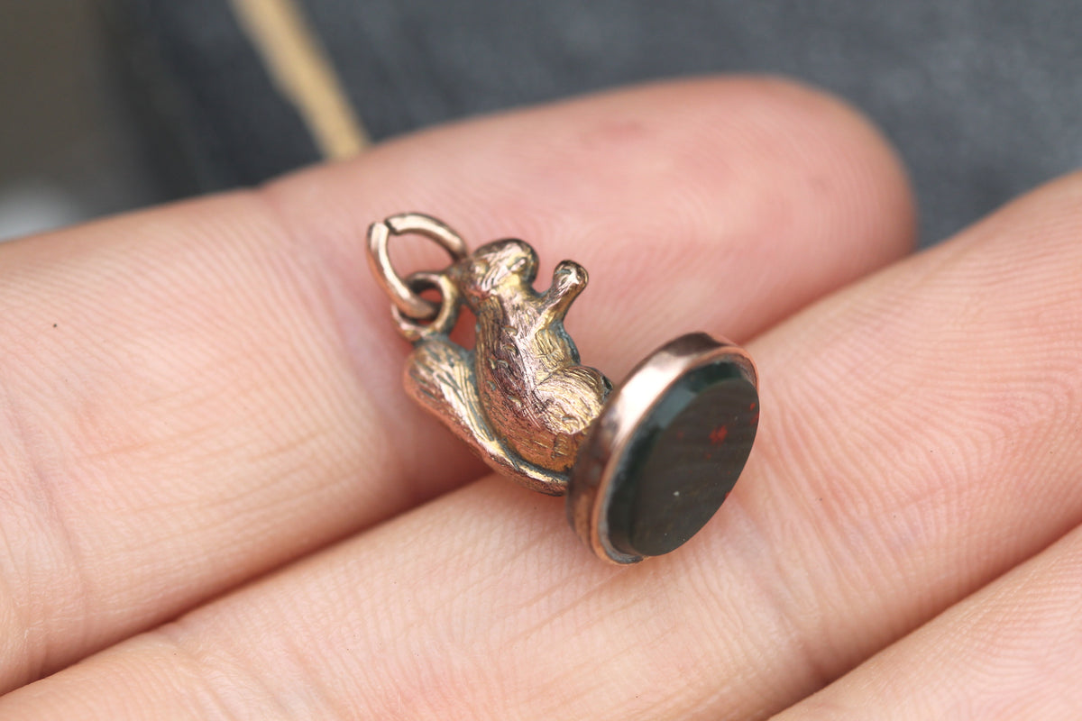 Antique rolled gold squirrel bloodstone charm held in hand