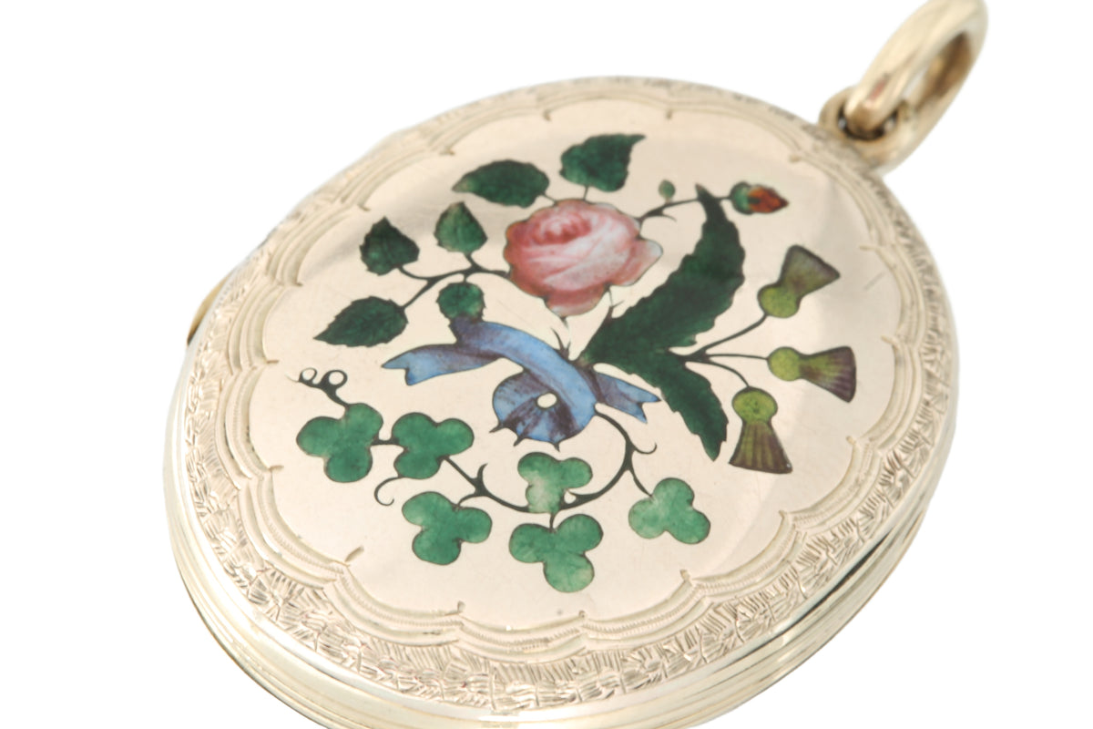 Close-up of enamel flowers and blue ribbon on Victorian gold locket