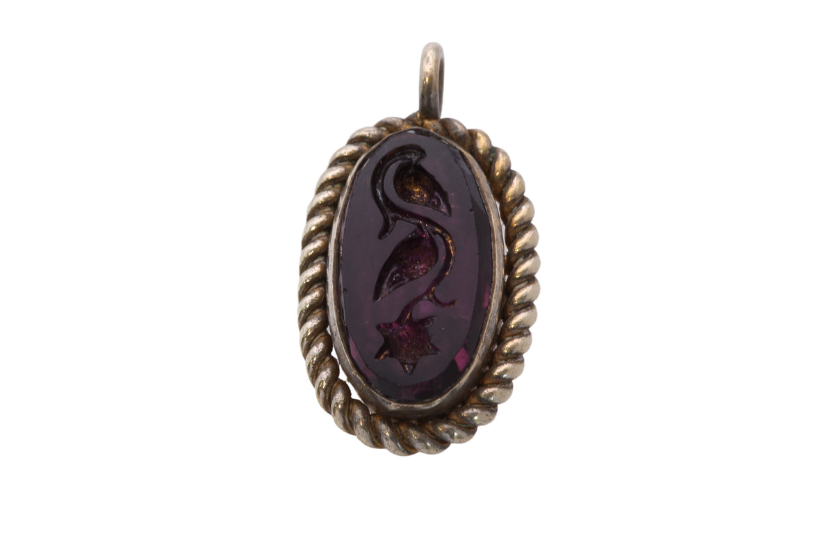 Side view showing twisted rope border around purple glass intaglio