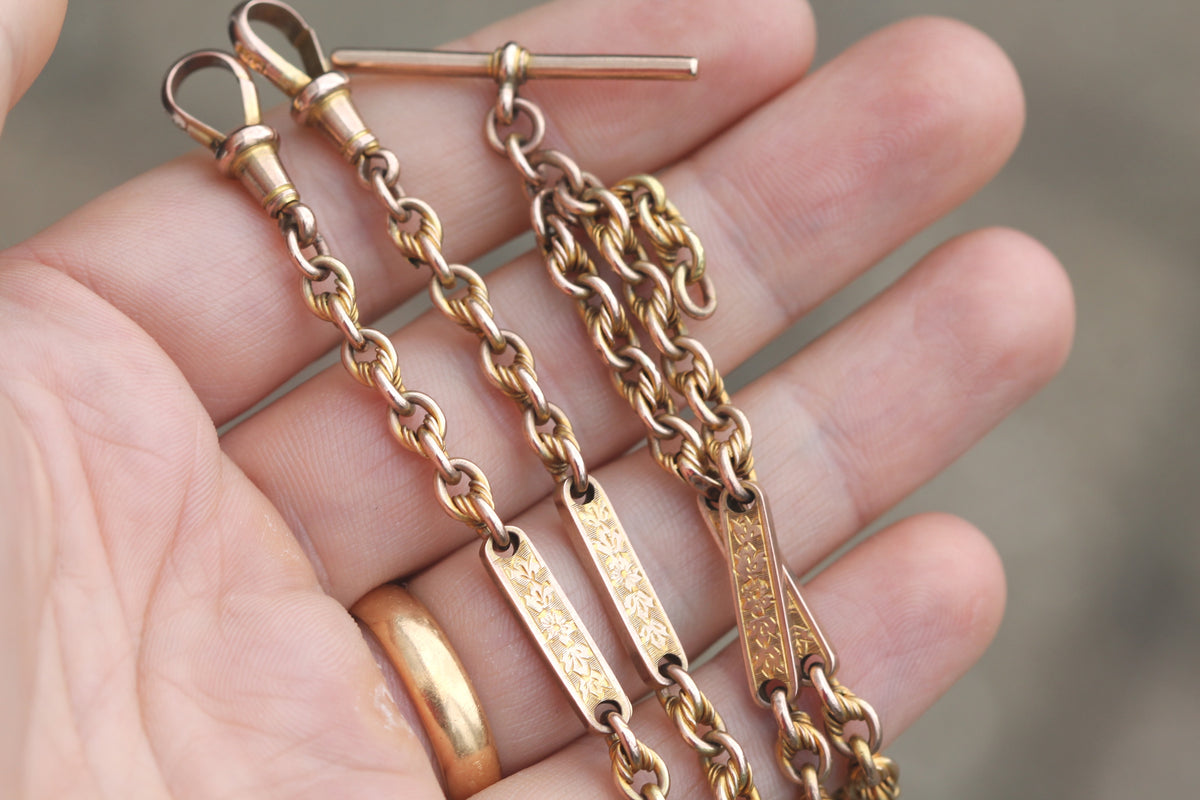 Victorian gold chain showing twin dog clips and chased floral bar links