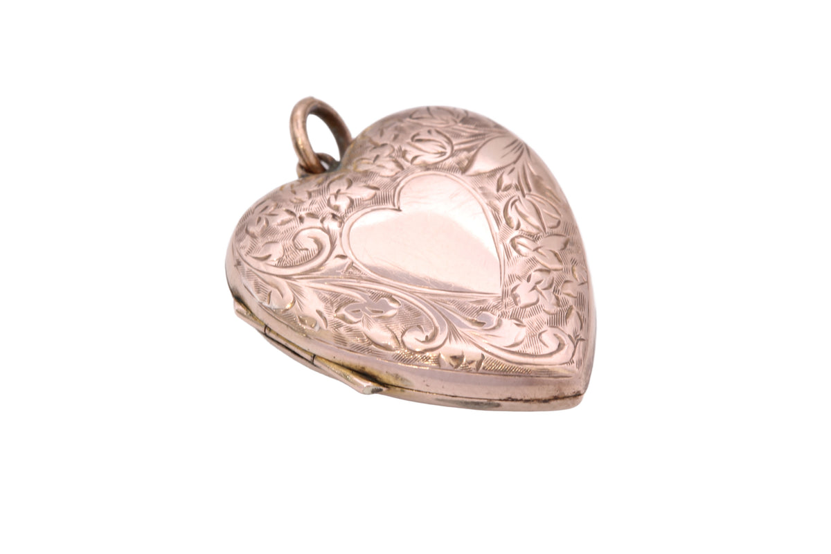 Victorian heart locket held in hand showing central heart cartouche