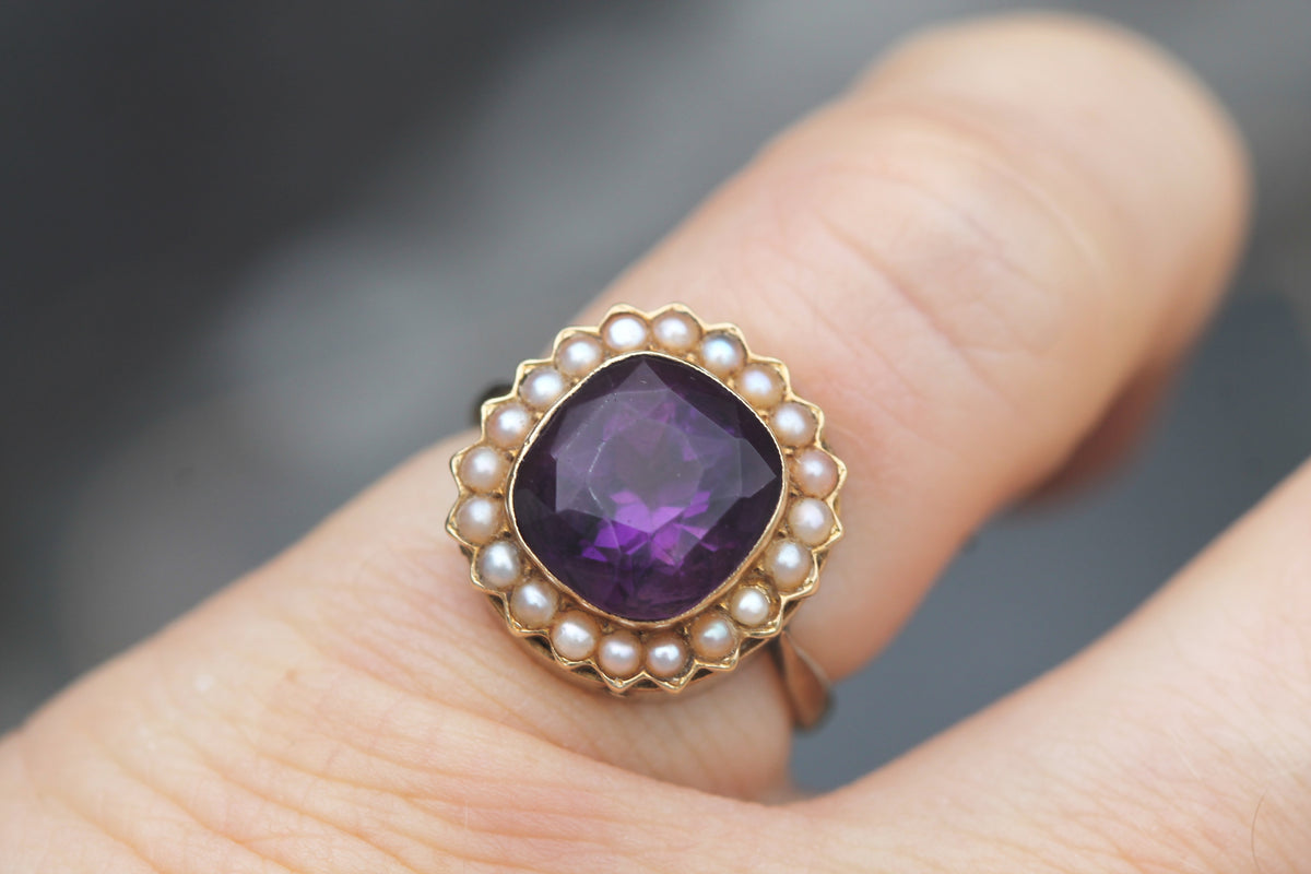Close-up of large purple amethyst surrounded by seed pearls