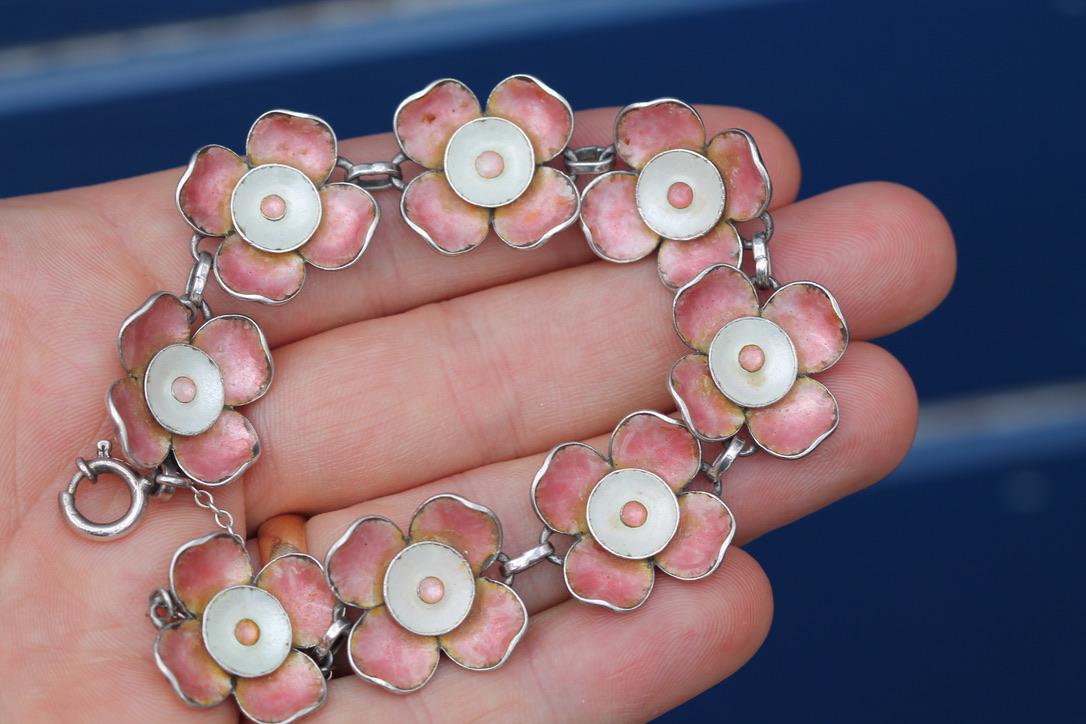 Close view of the articulated pink enamel flower links and white enamel centres